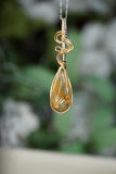 Close-up view of Wire-Wrapped Rutile Crystal Necklace in sterling silver .925 and 14 karat gold filled wire with sterling silver chain. showcasing intricate craftsmanship and the beauty of natural golden rutile crystals