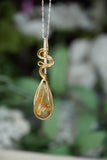 Close-up view of Wire-Wrapped Rutile Crystal Necklace in sterling silver .925 and 14 karat gold filled wire with sterling silver chain. showcasing intricate craftsmanship and the beauty of natural golden rutile crystals