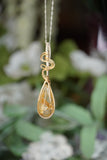 Close-up view of Wire-Wrapped Rutile Crystal Necklace in sterling silver .925 and 14 karat gold filled wire with sterling silver chain. showcasing intricate craftsmanship and the beauty of natural golden rutile crystals